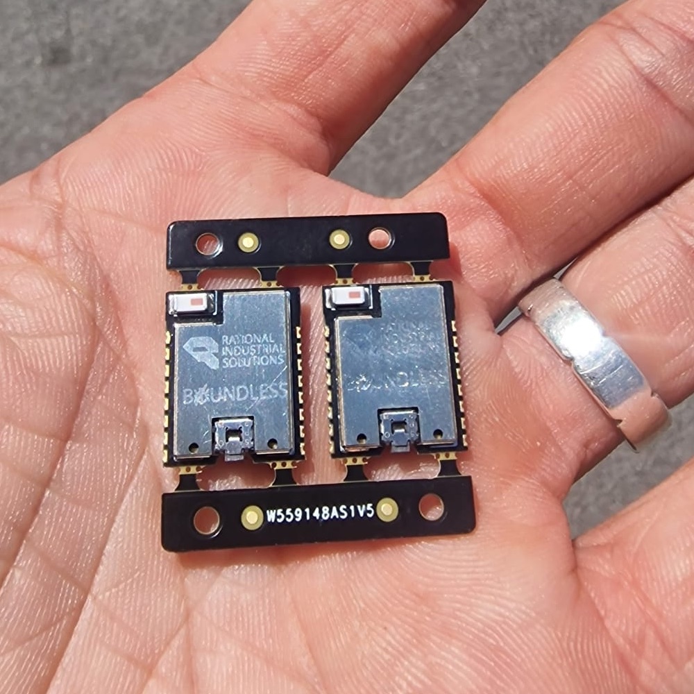 Two Boundless modules on their production panel, held in the palm of a hand