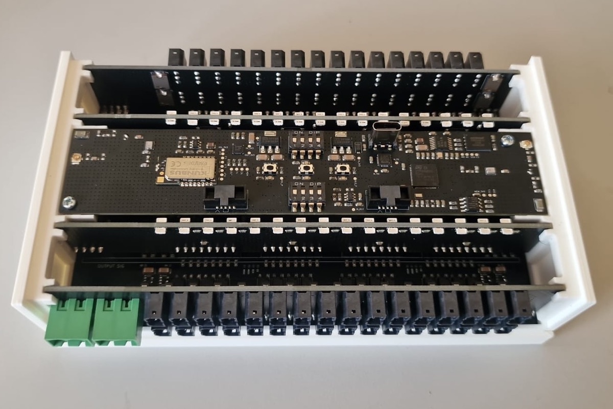 IO-Link Wireless IO adapter alpha unit: boards in a white housing with rows of IO connectors along the top and bottom